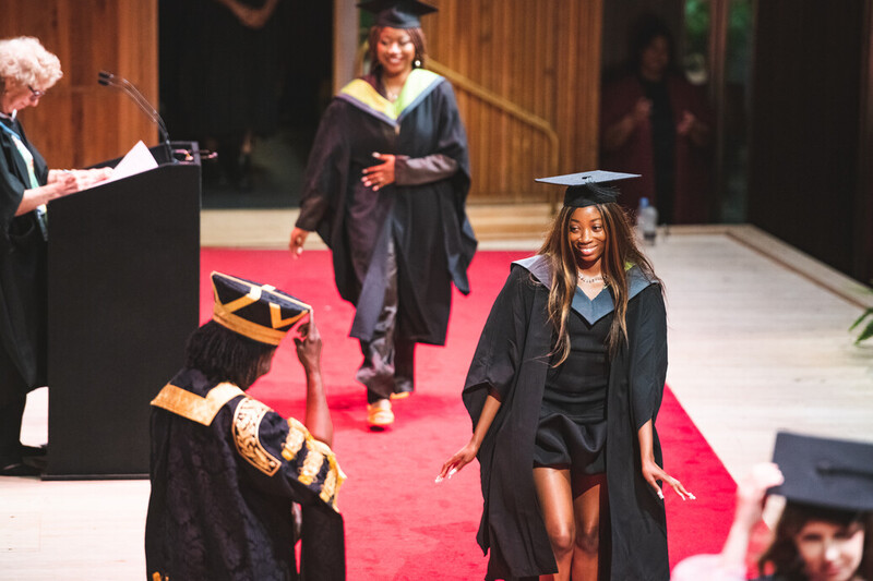 A UCA graduate excitedly accepts their award on stage